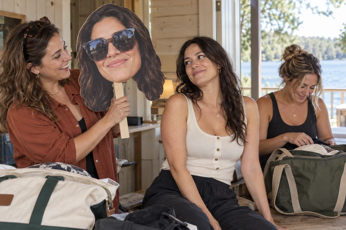 Friends getting ready at a lake cottage with a bride head sign that includes her sunglasses
